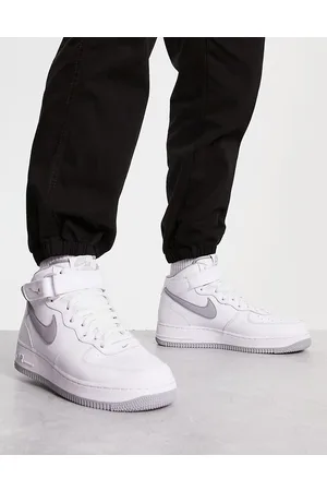 Nike Air Force 1 Mid trainers in white and